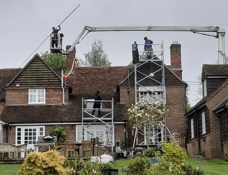 The Roof Moss Cleaners using cherry picker and scaffolding to clean roof safely and professionally in Epsom, Surrey